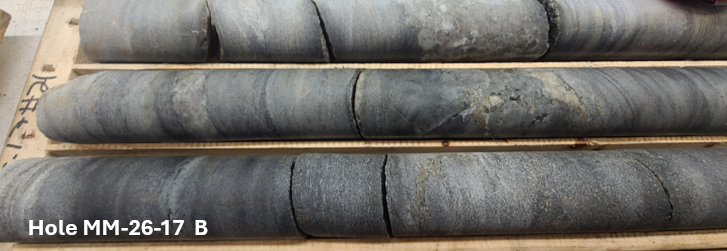 Drill core from ESGold hole MM-26-17 (photo B) in core boxes, showing quartz-carbonate veining with visible sulphides